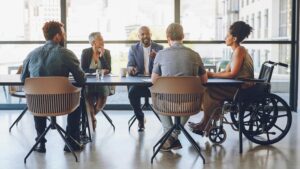 diverse group of employees sitting and talking at conference room table