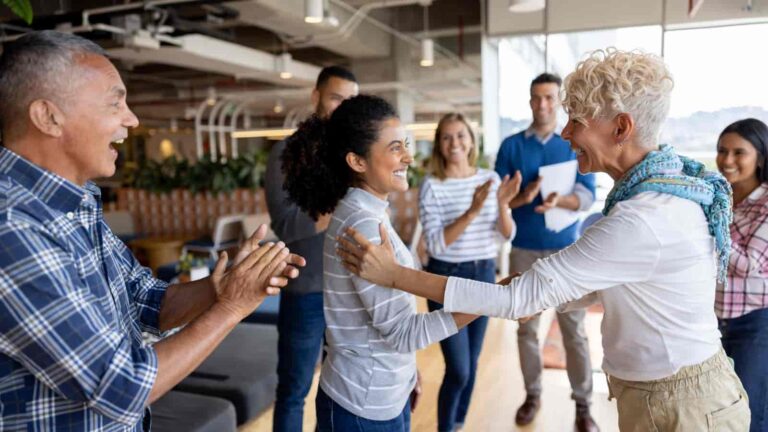 Multi-cultural office congratulating female employee