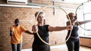 healthy senior citizens exercising in class with hula hoop