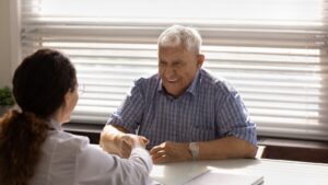 male senior citizen having discussion with medical provider